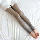Women’s fleece lined thermal stockings on gray leggings over white bedding
