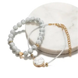 Marble-like beaded geometric bracelet in bohemian four-piece handmade jewelry set with gold accents and crescent moon charm