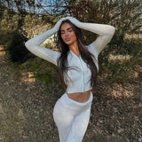 Woman in knitted hooded suit with high waist long sleeves trousers set