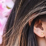 Gold shining star tassel earring in dark hair ear
