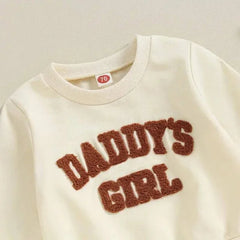 Cream-colored baby sweatshirt with Daddys Girl fuzzy text in stylish infant clothing set