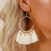 Stylish round drop dangle earrings with gold hoops and white tassels on decorative metalwork