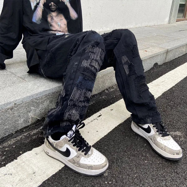 Distressed black jeans with rips and patches paired with Nike sneakers by 7TT Original National