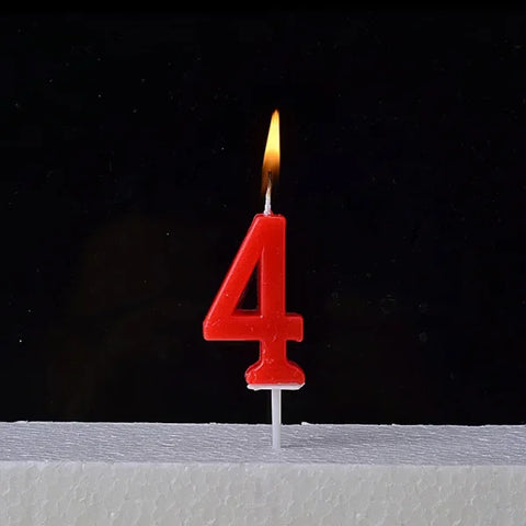 Lit red number 4 birthday candle atop a Champagne Gold Paraffin Candle