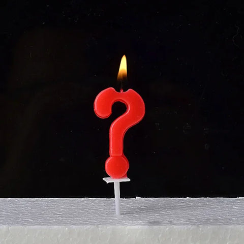 Lit red question mark candle on a Champagne Gold Paraffin Candle with ABS Materials