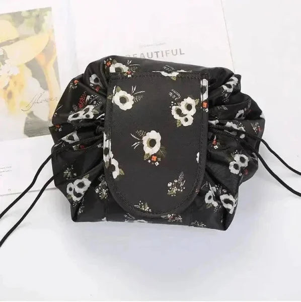 Black waterproof drawstring makeup organizer with white floral print for chic cosmetics