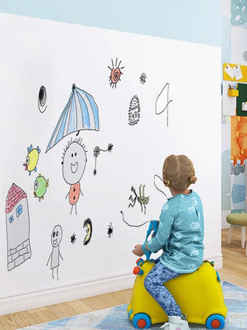 Child’s drawing on a white wall featuring stick figures and shapes on a whiteboard sticker