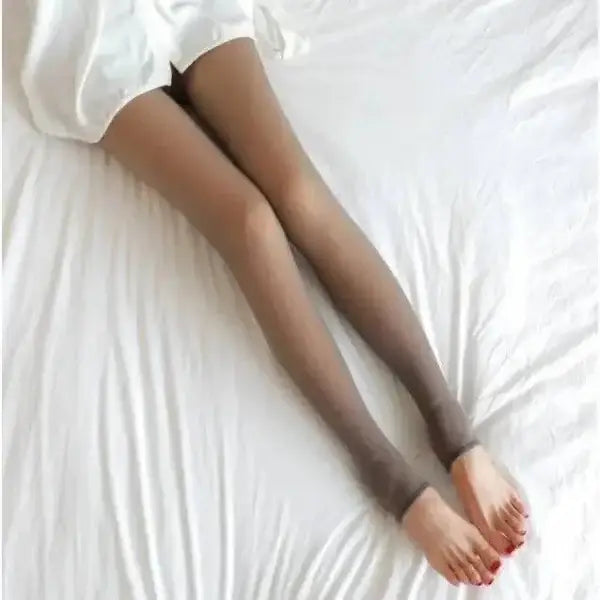 Women’s fleece lined thermal stockings with red toenails on white bedding