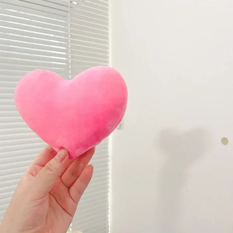 Pink plush heart held by a hand, perfect for Valentine’s Day as a seat cushion