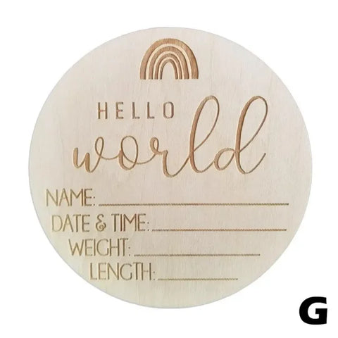 Wooden birth announcement disc with Hello World text and baby details on natural wood chips