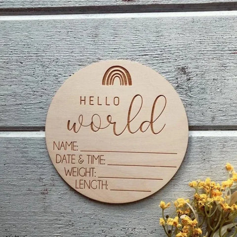 Wooden circular birth announcement sign featuring Hello World and spaces for baby details