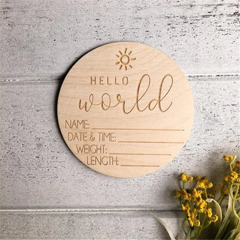 Wooden circular birth announcement disc engraved with Hello World and baby details, made from natural wood chips