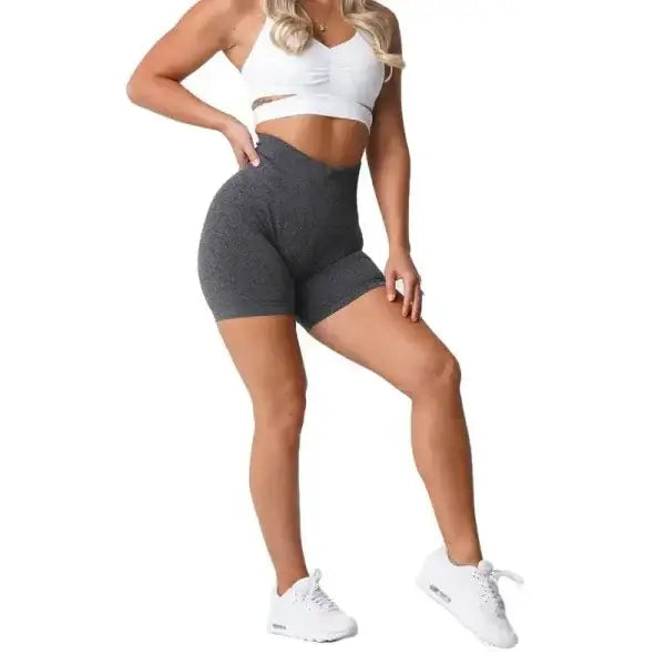 Nvgtn Seamless Pro Spandex Shorts in gray with white sports bra and sneakers