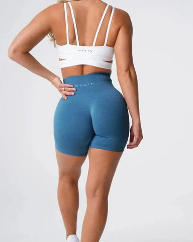 Blue high-waisted Nvgtn Seamless Pro Spandex Shorts paired with a white sports bra