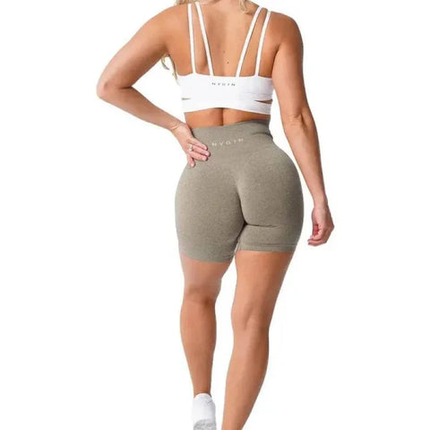 High-waisted taupe Nvgtn Seamless Pro Spandex Shorts with white sports bra