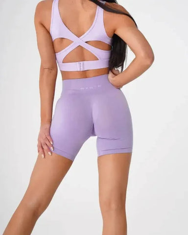 Lavender Nvgtn Seamless Pro Spandex workout set with strappy sports bra and biker shorts