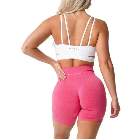 Pink high-waisted Pro Spandex Shorts with a white sports bra from Nvgtn Seamless Pro collection