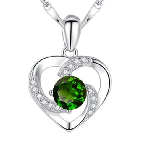 Silver heart-shaped pendant with emerald green gemstone on sterling silver necklace