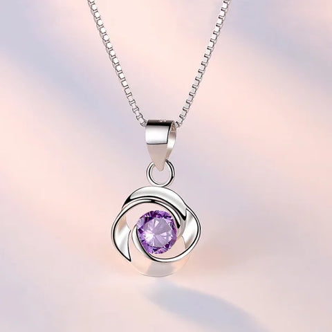 Sterling silver necklace pendant with purple gemstone in swirling silver design