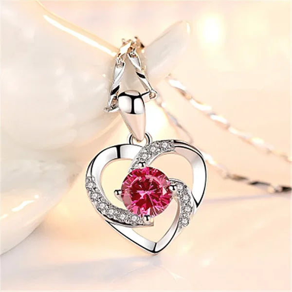 Heart-shaped silver pendant with pink gemstone and crystal accents in sterling silver necklace