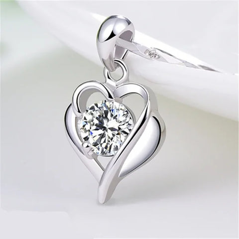 Sterling silver necklace pendant featuring a heart-shaped design with central diamond