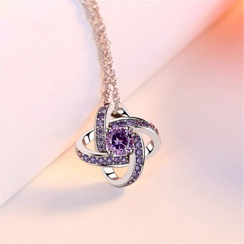 Sterling silver necklace pendant with swirling design and purple gemstones