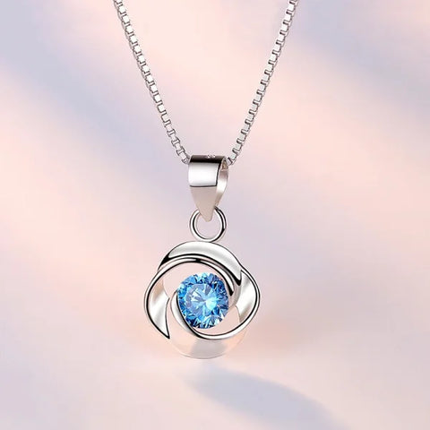 Sterling silver necklace pendant with blue crystal in elegant swirling design