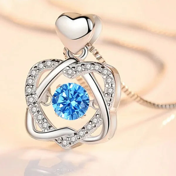 Sterling silver necklace pendant with blue gemstone and diamond accents, heart-shaped top