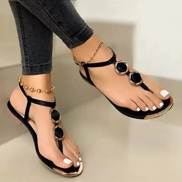 Stylish black and gold flat summer sandals with jeweled ankle chains